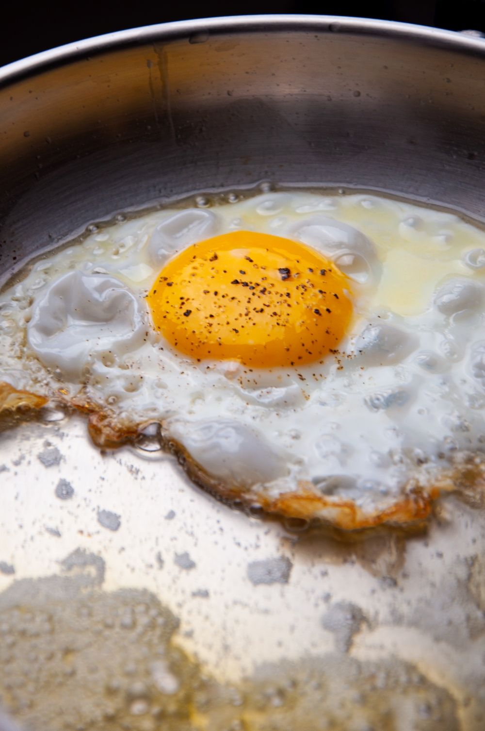 Frying egg until it has crispy golden edges