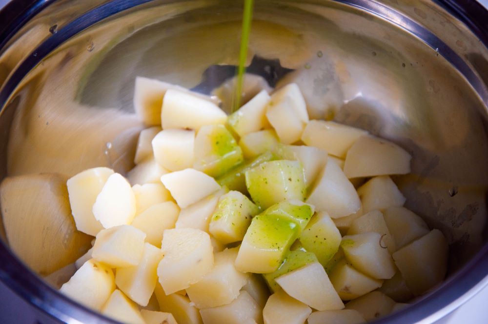 Adding extra virgin olive oil to the potatoes