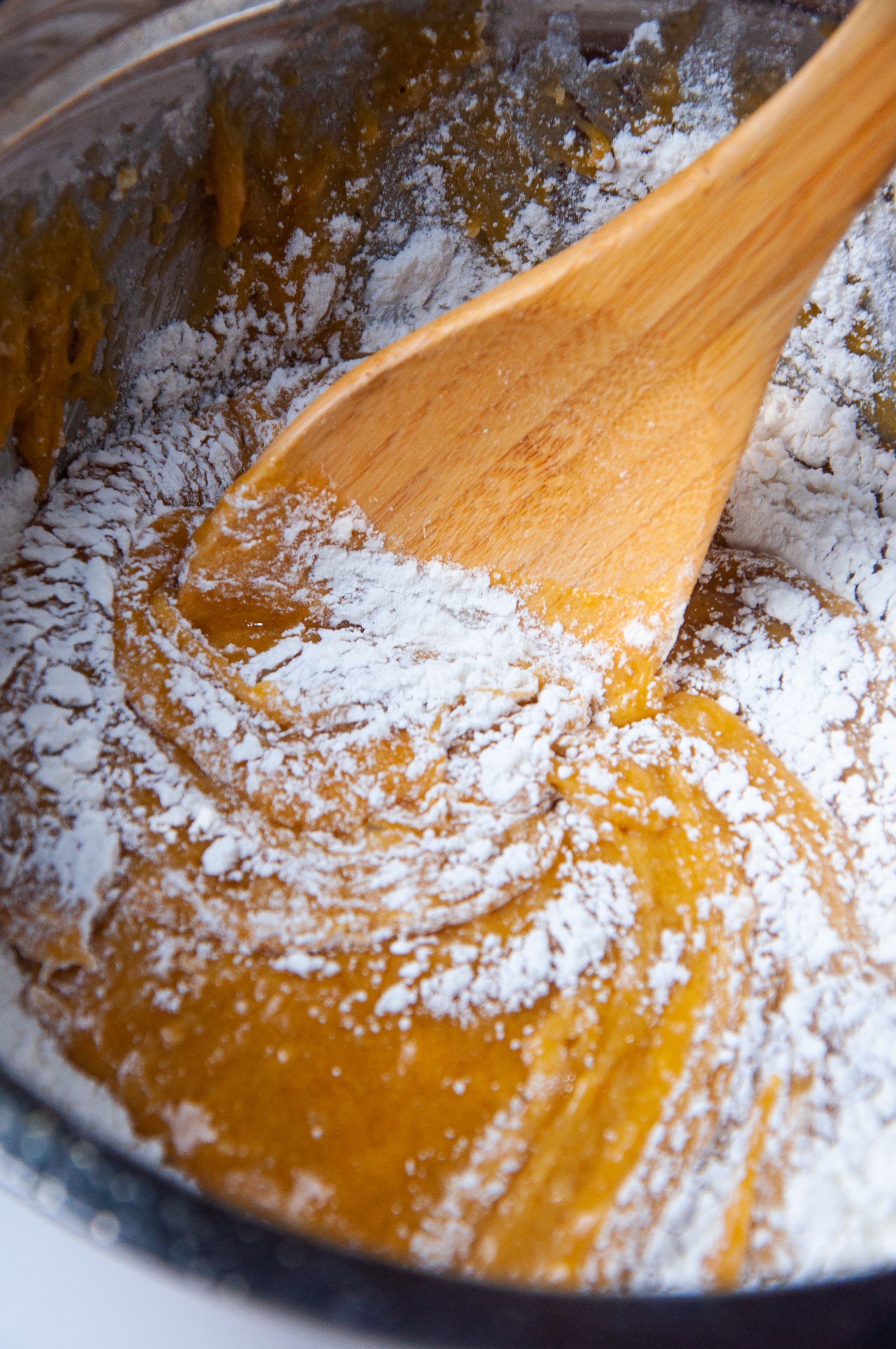 Adding the flour mixture and mixing slowly with a wooden spoon