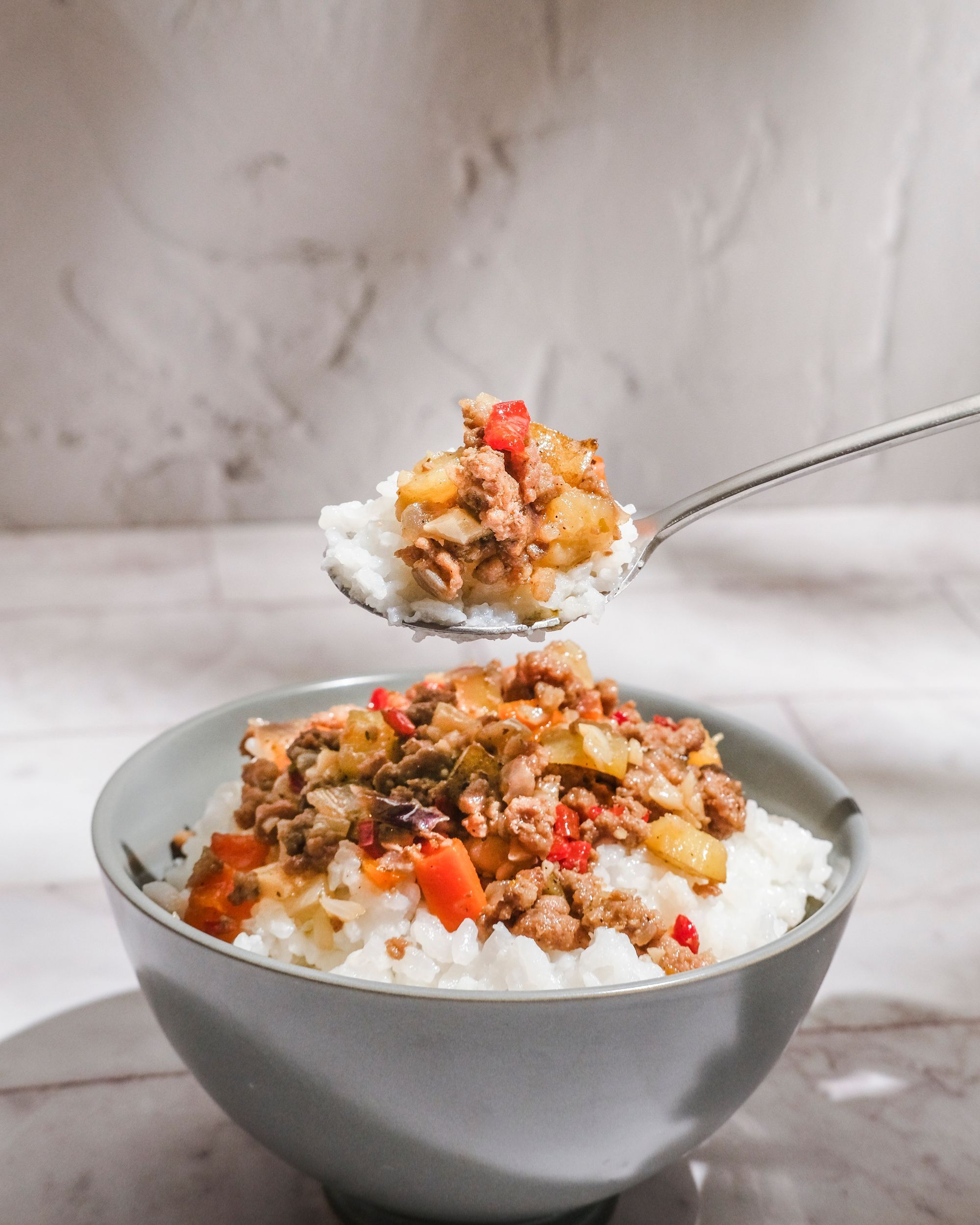 A spoonful of pork giniling with rice